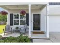 Inviting front porch with seating and decorative hanging flower baskets next to a black front door at 114 Forest Meadow Ct, Garner, NC 27529