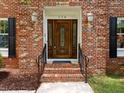 Close up of the front door to a brick home with black shutters and manicured yard at 116 Lost Tree Ln, Cary, NC 27513