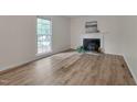 Spacious room with a fireplace and hardwood flooring, complemented by a large window at 1302 Valley Run Dr, Durham, NC 27707