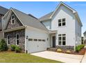 Two story home boasts stone accents, attached garage, and manicured lawn at 132 Cotten Dr, Morrisville, NC 27560