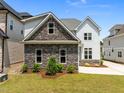 Two story home boasts stone accents, attached garage, and manicured lawn at 132 Cotten Dr, Morrisville, NC 27560