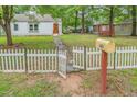Property featuring a white picket fence, mailbox, and swing set at 1401 Robinhood Rd, Durham, NC 27701