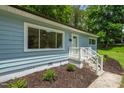 Close up exterior showcasing manicured landscaping, front stairs, and light blue facade at 1605 Nixon St, Durham, NC 27707