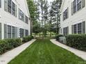 Exterior shot of condo community featuring a sidewalk and well-manicured lawn at 1911 Kudrow Ln, Morrisville, NC 27560
