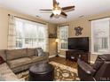 Bright living room with large windows, ceiling fan, and comfortable seating at 1911 Kudrow Ln, Morrisville, NC 27560