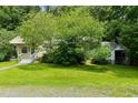 Cozy yellow home surrounded by lush greenery, offering a serene and private setting at 212 Plum St, Burlington, NC 27215