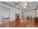 Spacious living room featuring hardwood floors, coffered ceiling, and a cozy brick fireplace at 212 Plum St, Burlington, NC 27215