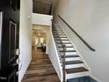 Inviting entryway with wood floors, a staircase, and views into the open-concept living area at 2417 Tobacco Root Dr, Raleigh, NC 27616