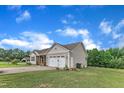 Home exterior, showcasing the garage, siding, and backyard surrounded by lush greenery, promoting a serene setting at 272 W Gennessee Dr, Zebulon, NC 27597