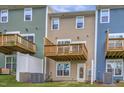 Rear view of townhomes showing private balconies and well-maintained yards at 2735 Hunter Woods Dr # 571, Apex, NC 27502