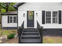 Close up of the front door entrance, black trim, brick steps and decorative wreath at 2809 Titleist Dr, Hillsborough, NC 27278
