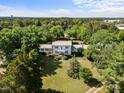 Aerial view of a sprawling home with manicured lawns, surrounded by lush trees, offering both privacy and curb appeal at 301 W Thorndale Dr, Oxford, NC 27565