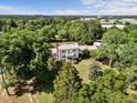 Picturesque two-story home featuring a metal roof, a charming balcony, and mature landscaping, nestled among lush trees at 301 W Thorndale Dr, Oxford, NC 27565