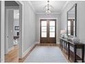 Inviting foyer with hardwood floors, elegant lighting, a decorative table, and access to other rooms at 310 Hidden Lake Dr, Youngsville, NC 27596