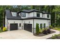 Beautiful home with a three-car garage, a mix of white siding and brick, and lush landscaping at 310 Hidden Lake Dr, Youngsville, NC 27596