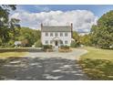 A beautiful colonial style house with mature landscaping and a circular driveway at 3679 Oak Lawn Farm Rd, Oxford, NC 27565