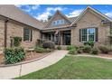 Close-up of home's entrance with inviting porch, detailed brickwork, and manicured landscaping along the walkway at 3728 Marwick Ct, Wendell, NC 27591