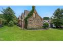 Charming stone and brick home with a well-manicured lawn and established landscaping at 407 Hillcrest Ave, Burlington, NC 27215