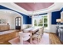 Elegant dining room featuring blue walls, a rustic table with seating for eight, and stylish chandelier at 4729 Adler Pass, Raleigh, NC 27612