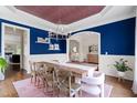 Elegant dining room featuring blue walls, a rustic table with seating for eight, and stylish chandelier at 4729 Adler Pass, Raleigh, NC 27612