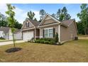 Charming home with stone accents, a two-car garage, landscaping, and a manicured lawn under a blue sky at 5081 Pioneer Dr, Sanford, NC 27330