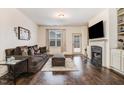 Cozy living room featuring a fireplace, large window, and hardwood floors at 51 Balboa Pkwy, Clayton, NC 27520