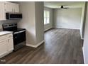 View from the kitchen showing the open floor plan into the freshly painted and floored living room at 510 North St, Graham, NC 27253