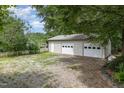 A detached two car garage featuring two doors, white trim and gravel driveway at 559 Blue Pond Rd, Clayton, NC 27520