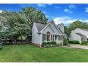 Landscaped home with blue siding, pretty lawn, driveway, mature trees, and blue sky at 8 Great Oak Ct, Durham, NC 27713