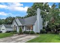 Landscaped home with blue siding, mature trees, chimney, driveway, and pretty lawn at 8 Great Oak Ct, Durham, NC 27713