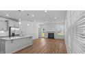 Bright, open-concept living room with modern gray cabinets, fireplace, and sleek stainless steel appliances at 807 Outlaw Ave # 19, Durham, NC 27703