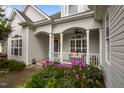 Inviting front porch features an outdoor seating area and lush purple flowers at 8116 Mosby Way, Willow Springs, NC 27592