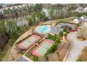 Beautiful aerial view of community pool, tennis courts, lake, and surrounding trees at 8151 Rhiannon Rd, Raleigh, NC 27613