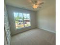 Bright bedroom with a ceiling fan, a large window, and plush carpeting at 85 Bald Cypress Ln, Youngsville, NC 27596