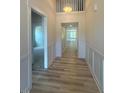 Bright hallway with hardwood floors, white wainscoting, and access to multiple rooms at 85 Bald Cypress Ln, Youngsville, NC 27596