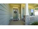 Inviting covered front porch features stone accents, decorative wreath and charming decor at 966 Airedale Trl, Garner, NC 27529