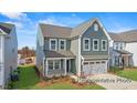 Charming two-story home with gray siding, a well-kept lawn, and a two-car garage at 106 S Buggy Dr # 70, Benson, NC 27504