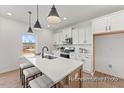Contemporary kitchen featuring a breakfast bar, white cabinets, and modern appliances at 106 S Buggy Dr # 70, Benson, NC 27504