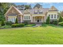 Charming two-story home featuring stone accents, manicured landscaping, and inviting front porch on a sunny day at 1096 Silverleaf Dr, Youngsville, NC 27596