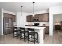A modern kitchen offers an island with bar seating, pendant lights, and stainless steel appliances at 11751 Salers Loop Loop, Middlesex, NC 27557