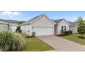 One-story home with attached garage, concrete driveway, well-manicured lawn, and appealing landscaping at 119 Yadkin St, Clayton, NC 27520