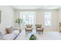 Inviting living room showcasing a comfortable sofa and two armchairs with views through large windows at 1359 Chowan Ave, Durham, NC 27713