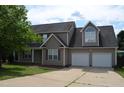 Charming home with a two car garage, manicured lawn and a mature tree, partly cloudy sky at 136 Wedgewood Ct, Sanford, NC 27332