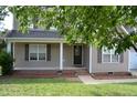 Inviting front porch with brick trim, neutral siding, and a well-manicured lawn at 136 Wedgewood Ct, Sanford, NC 27332