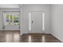 Inviting foyer with hardwood floors, a white front door, and natural light from a window at 1414 Arena Ln, Fuquay Varina, NC 27526