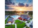 Aerial view showcases a resort style community pool and amenity center set among lush trees and landscaping at 152 Serene Xing, Fuquay Varina, NC 27526
