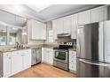 Bright kitchen featuring stainless steel appliances, granite countertops, and white cabinets at 2 Lake Village Dr, Durham, NC 27713