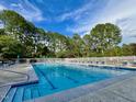Community pool with clear blue water, surrounded by a white fence and mature trees at 2 Lake Village Dr, Durham, NC 27713