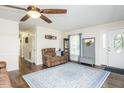 Cozy living room with hardwood floors, ceiling fan, and ample natural light from the front door at 2120 Northcrest Dr, Elon, NC 27244