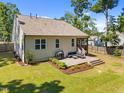 Back of house featuring a spacious deck with patio furniture and manicured landscaping at 2321 Blue Crab Ct, Wake Forest, NC 27587